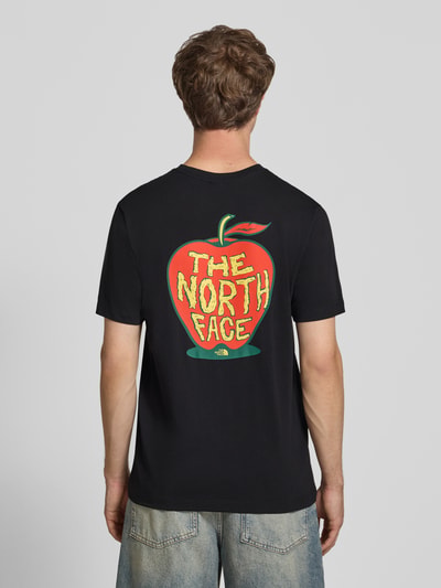 Männermodel trägt Regular Fit T-Shirt mit Motiv-Print auf der Rückseite von The North Face, Baumwolle, Schwarz, Ganzkörperansicht Rückansicht.