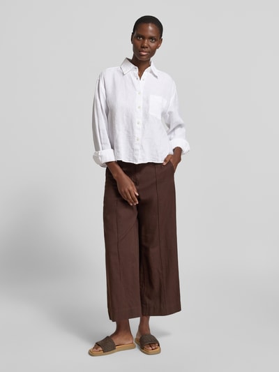 Männermodel trägt Relaxed Fit Hemdbluse aus reinem Leinen von Marc O'Polo, kolor biały, luźny krój, kołnierzyk koszulowy, długi rękaw, kieszeń na piersi, materiał czysty len, widok całej sylwetki z przodu.