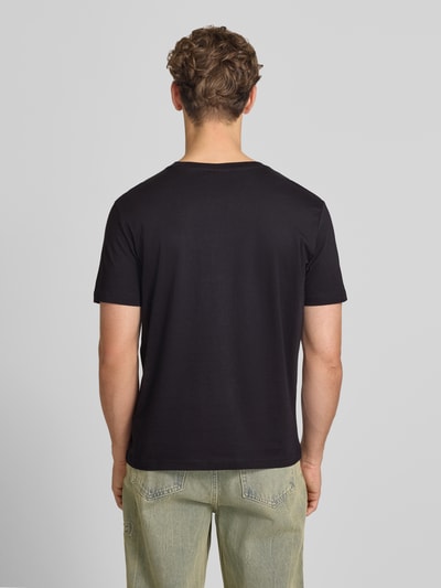 Männermodel trägt T-Shirt mit Label-Stitching mit Rundhalsausschnitt von CHAMPION aus Reine Baumwolle, Regular-Fit, Rückenlänge 68 cm, Ganzkörperansicht Rückansicht.