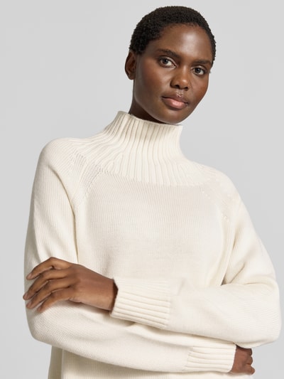 Vrouwenmodel draagt gebreide pullover uit puur linnen van MICHAEL Michael Kors in crème, opstaande kraag in riblook, Raglanmouwen, ribboorden, los model, ruglengte maat S 67 cm, mouwlengte maat S 48 cm, Nahaufnahme bovenlichaam.