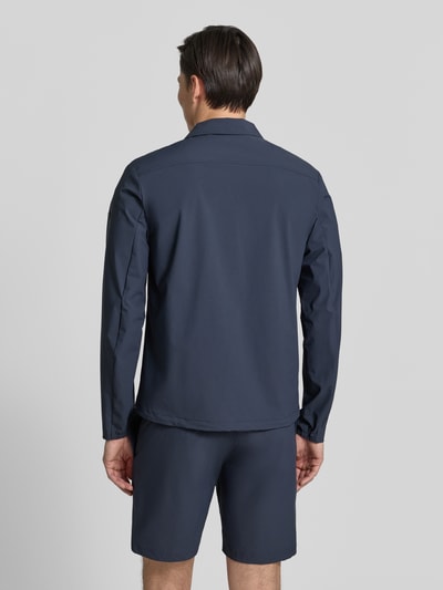 Männermodel trägt Regular Fit Jacke mit Umlegekragen Modell 'Motion' von SCANDINAVIAN EDITION in Dunkelblau, Rückenansicht Ganzkörperansicht. Elastischer Material-Mix, Napoleontasche, Zweiwege-Reißverschluss, Eingrifftaschen.