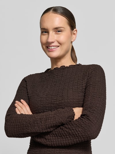 Frauenmodel trägt Regular Fit Langarmshirt aus Baumwoll-Mix Modell 'ZIA' von VERO MODA in Dunkelbraun mit strukturierter Oberfläche, Nahaufnahme Oberkörper, Damen Langarmshirt von VERO MODA.