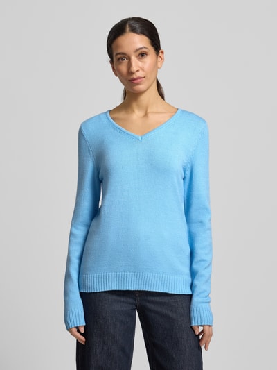 Frauenmodel trägt Regular Fit Longsleeve aus Viskose in Strick-Optik Modell 'Viril' von Vila in Hellblau mit V-Ausschnitt, Ganzkörperansicht von vorne.