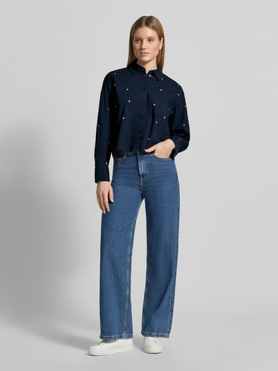 Frauenmodel trägt Boxy Fit Hemdbluse aus reiner Baumwolle von Tom Tailor Denim, Optik: Unifarben mit Allover-Stickerei, Boxy-Fit, Hemdblusenkragen, Cropped, Langarm, Brusttasche, reine Baumwolle, Ganzkörperansicht von vorne.