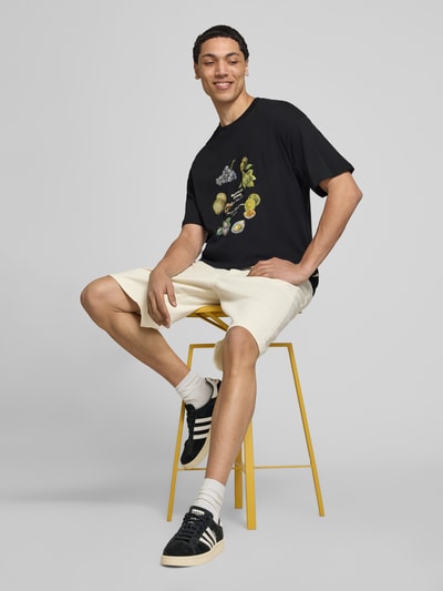 Männermodel trägt T-Shirt mit Rundhalsausschnitt von Jack & Jones aus Reine Baumwolle, Regular-Fit, Print, Rückenlänge 70 cm, Ganzkörperansicht von vorne.