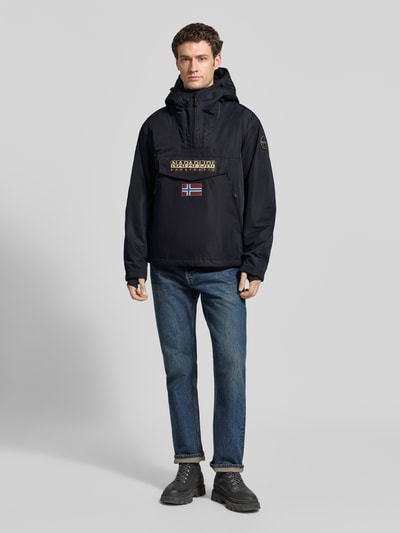 Männermodel trägt Jacke mit Kapuze und kurzem ritssluiting van Napapijri, recht model, Klepzak, labelpatches, donkerblauw, Ganzkörperansicht von vorne