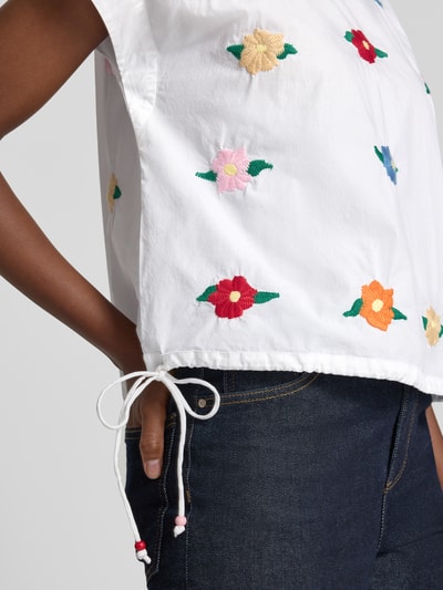 Kobiecy model nosi Blusenshirt mit Stitchings und seitlicher Schnürung od Rich & Royal, bawełna, krój regular fit, hafty, okrągły dekolt, wiązanie po bokach, Długość tyłu w rozmiarze 36: 52 cm, zbliżenie na górną część ciała.