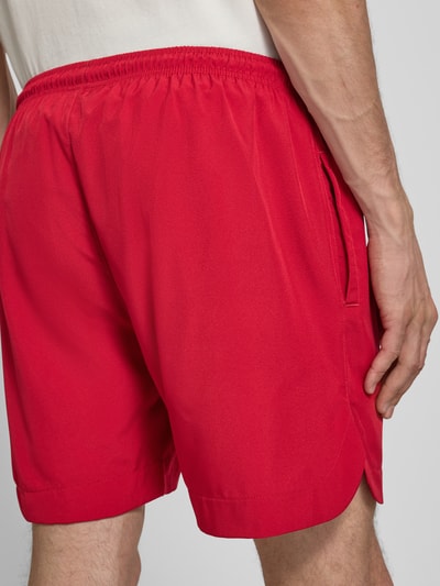 Männermodel trägt Badehose mit Label-Stitching und elastischem Bund von PROHIBITED in Rot, Regular-Fit, Rückansicht, Nahaufnahme Oberkörper.