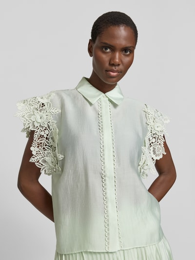 Frauenmodel trägt Regular Fit Bluse mit Spitzenbesatz Modell 'MOLLY' von Copenhagen Muse im hellen Material-Mix mit Stretch-Anteil, Hemdblusenkragen, verdeckte Knopfleiste, Rückenlänge 62 cm, Ärmellänge 10 cm, Ganzkörperansicht von vorne.