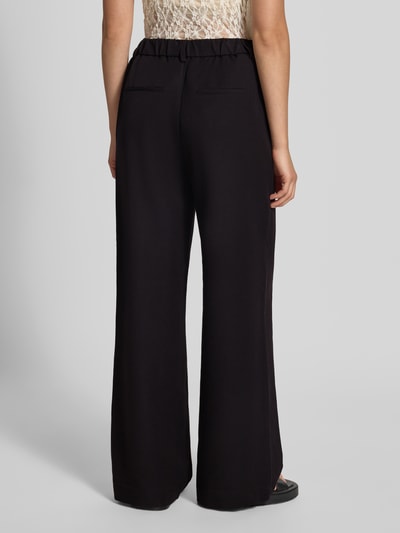 Vrouwenmodel draagt zwarte wijdte broek met viscose van PIECES, model 'KAMIL', Dames Weite Hose, volledige lichaamsaanzicht van achteren.