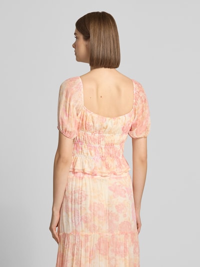 Frauenmodel trägt Blusenshirt aus Viskose mit Schnürung Modell 'Maelle' von OH APRIL, florales Muster in Rosa und Beige, Ganzkörperansicht Rückansicht.
