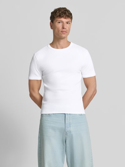 Męski model nosi T-Shirt in Ripp-Optik mit Rundhalsausschnitt von Jake*s, mieszanka bawełny i elastanu, krój slim fit, długość tyłu w rozmiarze M: 56 cm, jasnobiałe kolory, gładka tekstura, widok całej sylwetki z przodu.