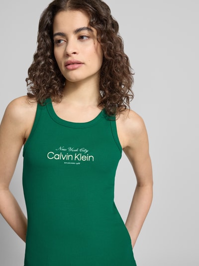 Kobiece model prezentuje Top mit Label-Stitching Modell 'CONTOUR' von Calvin Klein Jeans z mieszanki bawełny, dopasowany krój, dekolt w łódkę, wyhaftowane logo, zielony materiał o prążkowanej fakturze, długość tyłu w rozmiarze S: 48 cm, zbliżenie na górną część ciała