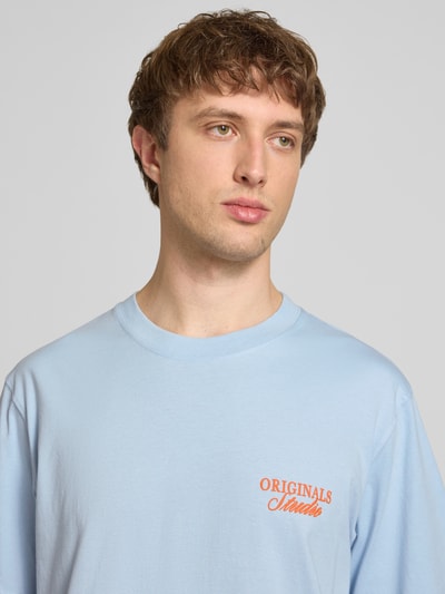 Männermodel trägt T-Shirt mit Label-Print von Jack & Jones in Hellblau aus reiner Baumwolle, Rundhalsausschnitt, Nahaufnahme Oberkörper.
