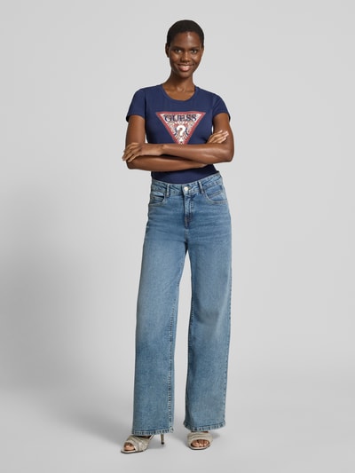 Vrouwenmodel draagt T-shirt met logo en ronde hals van Guess, mix van katoen en elastaan, slim fit, ruglengte maat S 58 cm, full-body vooraanzicht