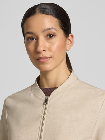 Frauenmodel trägt Regular Fit Blouson mit Viskose-Anteil von s.Oliver BLACK LABEL, efekt: jednolity kolor, melanż, krój regular fit, kształt kołnierza: kołnierz college, zapięcie: zamek błyskawiczny, rękaw: długi rękaw, nakładana boczna kieszeń, wykończenie materiału: batyst, materiał: mieszanka materiałów z dodatkiem wiskozy, kolor beżowy, gładka faktura. Nahaufnahme górnej części ciała.