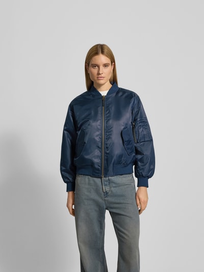 Frauenmodel trägt Bomberjacke mit Reißverschluss von Anine Bing, dunkelblau, Lockerer-Schnitt, Gerippte-Abschlüsse, Stehkragen, Pattentaschen, Rückenlänge 59 cm, Brustweite 63 cm, Ärmellänge 61 cm, Ganzkörperansicht von vorne.