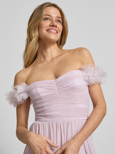 Modelka kobieca nosi 'Abendkleid mit floralen Applikationen und Carmen-Ausschnitt' od Lipsy, jasnoróżowy szyfon, A-linia, florystyczne aplikacje, dekolt typu carmen, zapięcie na haczyk i zamek z tyłu, długość pleców w rozmiarze 36: 25 cm, szerokość w rozmiarze 36: 30 cm, zdjęcie z przodu, ujęcie górnej części ciała.