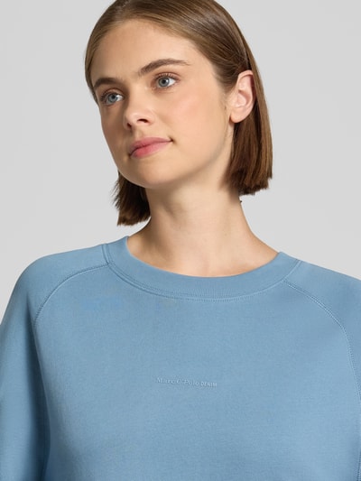 Frauenmodel trägt Regular Fit Sweatshirt aus reiner Baumwolle von Marc O'Polo DENIM in Hellblau, glatte Textur, Nahaufnahme Oberkörper.