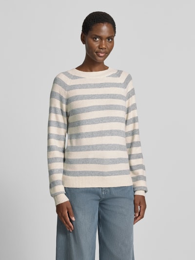 Frauenmodel trägt Regular Fit Pullover mit Streifen Modell 'DOFFY' von VERO MODA in Creme und Grau, lockere Passform, Ganzkörperansicht von vorne.