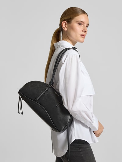 Frauenmodel trägt Shoulder Bag aus echtem Leder Modell 'Capri' von LIEBESKIND BERLIN in Schwarz, Textur fein genarbt, Nahaufnahme Oberkörper. Breite 37 cm, Länge 17 cm, Tiefe 13 cm, Länge Schulterriemen 68 cm, Logo-Detail sichtbar.