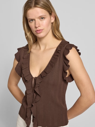Frauenmodel trägt Slim Fit Strick-Top aus Viskose-Mix Modell 'NELLY' von Only, braun, unifarben, Rüschen, tiefes V, ärmellos, Nahaufnahme Oberkörper.