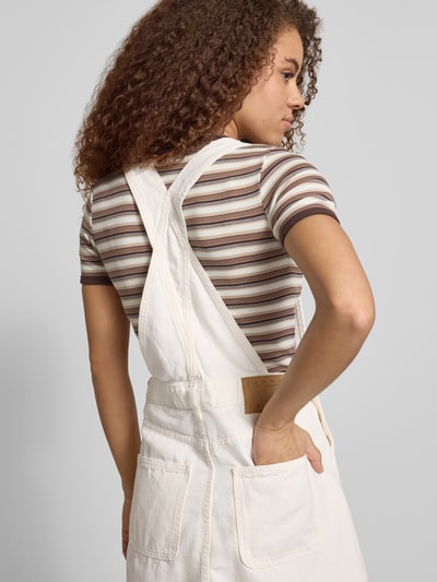 Frauenmodel trägt Leicht ausgestelltes Jeanskleid aus reiner Baumwolle von Tommy Jeans in Denim-Optik mit Label-Stitching-Applikation, Mini-Länge, seitlichen Eingrifftaschen und Brusttasche, Ganzkörperansicht Rückansicht.