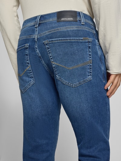 Männermodel trägt Regular Fit Jeans im 5-Pocket-Design Modell 'Lyon' von Pierre Cardin, mittelblau, Nahaufnahme Rückansicht. Elastischer Baumwoll-Mix mit Lyocell-Anteil, sichtbares Markenlabel.