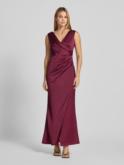 Frauenmodel trägt Abendkleid mit Raffungen von Rinascimento in bordeauxrot, Satin, V-Ausschnitt, ärmellos, Ganzkörperansicht von vorne.