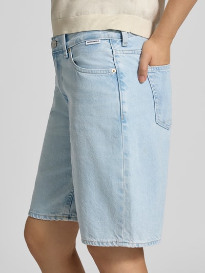 Vrouwenmodel draagt lichte korte jeans van katoen, Regular Fit Jeansshorts aus reiner Baumwolle model 'THALINAA' van Armedangels, detailopname zijkant, Dames Jeansshorts van Armedangels.