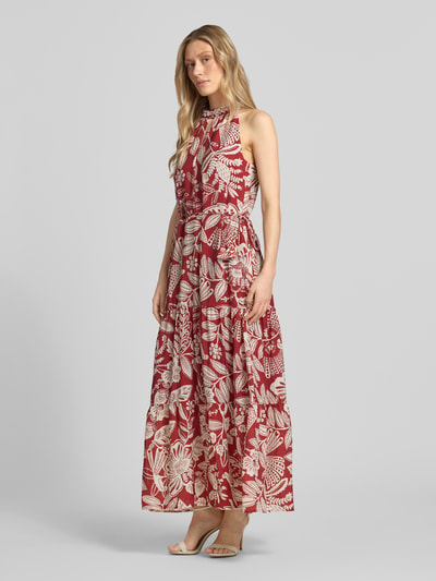 Modelka nosi Midikleid aus Viskose-Mix mit Schlüsselloch-Ausschnitt od Oui, czerwono-biały wzór, taśma w talii, kryształki, cekiny, dół z falbaną, cienka tekstura, długość tyłu 140 cm, szerokość w rozmiarze 36: 47 cm, widok całej sylwetki z przodu.
