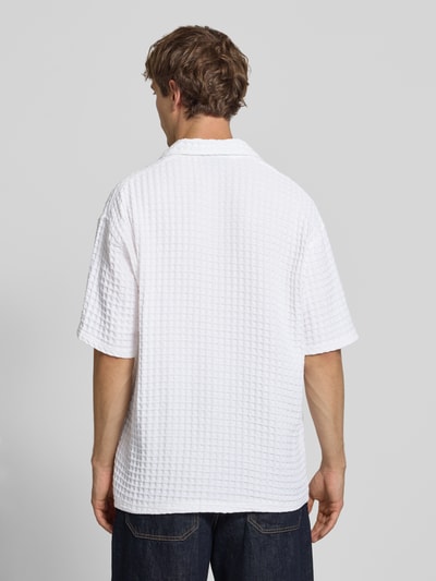 Männermodel trägt Relaxed Fit Freizeithemd mit Strukturmuster von PEGADOR in Weiß, reine Baumwolle, kurze Ärmel, Ganzkörperansicht Rückansicht.