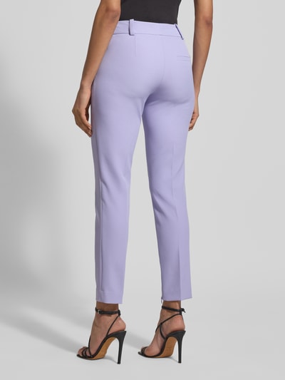 Frauenmodel trägt Slim Fit Schmale Hose mit Label-Applikation Modell 'HEDIMA-1' von HUGO in Flieder, unifarben, Ganzkörperansicht Rückansicht.