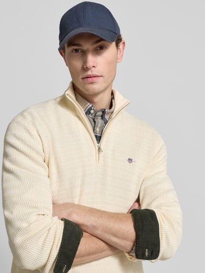 Männermodel trägt Strickpullover mit Stehkragen von Gant, Reine Baumwolle, Regular-Fit, Label-Stitching, Nahaufnahme Oberkörper.