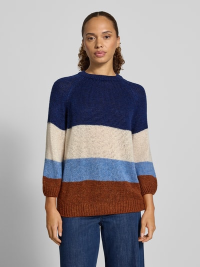 Frauenmodel trägt Relaxed Fit Pullover mit Woll-Anteil in Strick-Optik von MORE & MORE, Blockstreifen in Blau, Beige, Braun, Ganzkörperansicht von vorne.