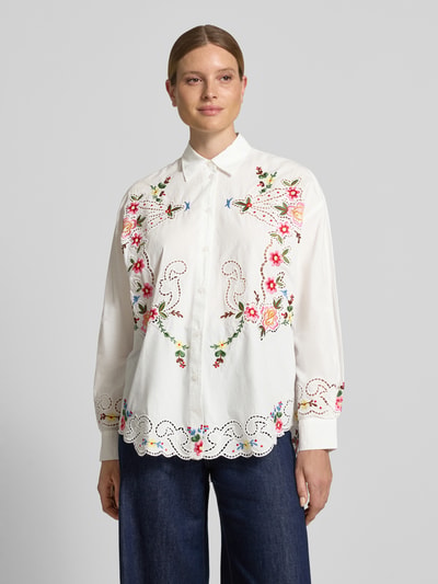 Frauenmodel trägt weiße Langarmbluse Modell 'JAYME' von Essentiel Antwerp mit farbigen Blumenstickereien, Ganzkörperansicht von vorne. Damen Langarmbluse