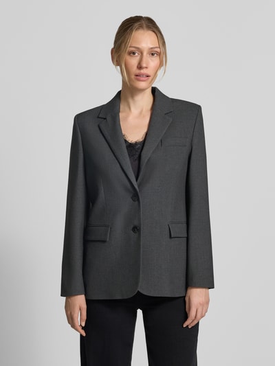 Frauenmodel trägt Blazer mit Viskose-Anteil Modell 'Bergen' von MANGO, dunkelgrau, tailliert, glatte Textur, Ganzkörperansicht von vorne.