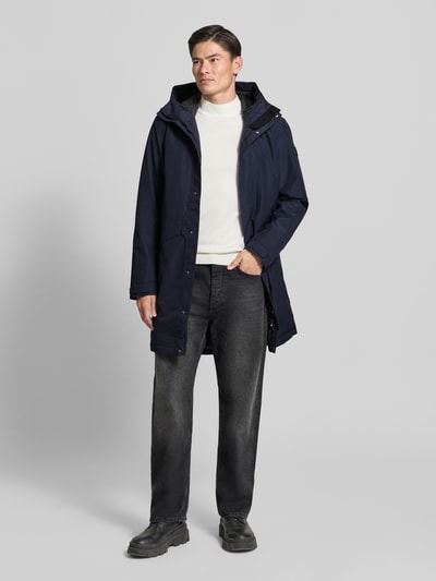 Männermodel trägt Regular Fit Parka mit Kapuze Modell 'Kenny' von Didriksons in Dunkelblau, weiße Textur, Eingrifftaschen, Ganzkörperansicht von vorne. Rückenlänge 99 cm, Schulterbreite 48 cm, Brustweite 59 cm, Ärmellänge 72 cm.