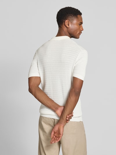 Männermodel trägt Slim Fit Strick-Poloshirt mit Strukturmuster Modell 'BRAIAN' von Drykorn in Weiß, reine Baumwolle, Rückansicht, Ganzkörperansicht.