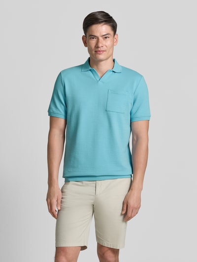 Männermodel trägt Regular Fit Poloshirt aus Baumwoll-Mix von s.Oliver RED LABEL in Hellblau, strukturierte Seersucker-Optik, Polokragen, kurzarm, V-Ausschnitt, gerippte Bündchen, Brusttasche, unifarben, Ganzkörperansicht von vorne.