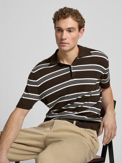 Männermodel trägt Poloshirt aus Baumwoll-Lyocell-Mix mit Kaschmir-Anteil mit gerippten Abschlüssen von FTC-Cashmere, braun mit weißen Streifen, Regular Fit, Polokragen, kurze Knopfleiste, Ganzkörperansicht von vorne.