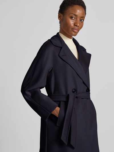 Frauenmodel trägt Regular Fit Mantel aus reiner Schurwolle Modell 'RESINA' von Weekend Max Mara in dunklem Blau, feine Textur, Nahaufnahme Oberkörper.