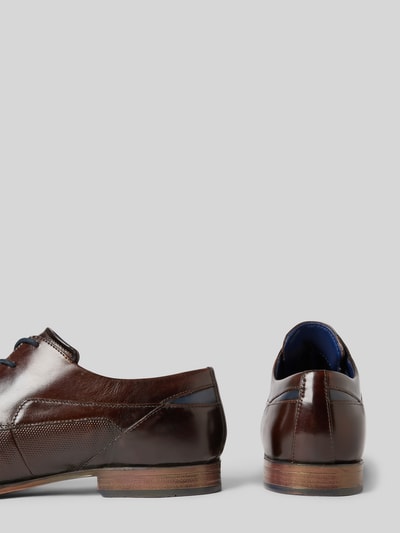 Produktfoto, Buty sznurowane z naturalnej skóry, zaokrąglony czubek, detal z logo, fakturowana podeszwa, model 'Morino' od Bugatti, wysokość obcasa 3 cm, cholewka 7 cm, szerokość cholewki 7 cm, brązowy kolor, gładkie i fakturowane powierzchnie.