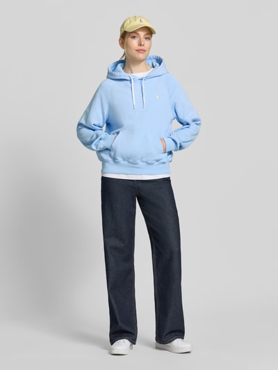 Frauenmodel trägt Regular Fit Hoodie aus Baumwoll-Mix von Polo Ralph Lauren in Optik: Unifarben mit Logo-Stitching, Kängurutasche, Sweat, Ganzkörperansicht von vorne.