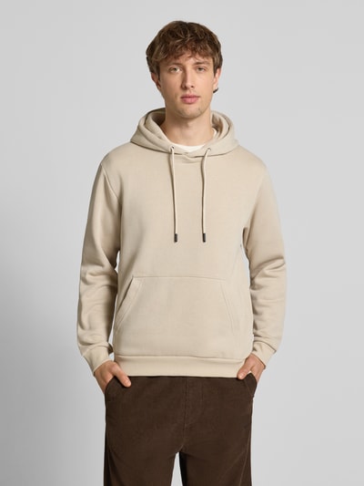 Männermodel trägt Hoodie mit Kapuze Modell 'BRADLEY' von Jack & Jones in Beige, lockerer Schnitt, Känguru-Tasche, Ganzkörperansicht von vorne.