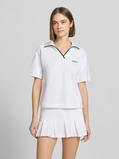 Frauenmodel trägt Regular Fit Poloshirt mit Logo-Stitching von adidas Sportswear, weiß, grüne Details, Baumwolle, Ganzkörperansicht von vorne.
