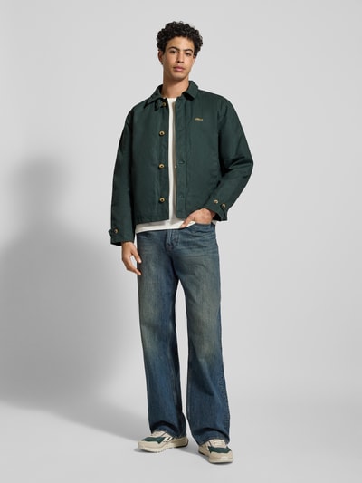 Männermodel trägt Jacke mit Label-Stitching und Eingrifftaschen von BLKVIS, Reine Baumwolle, Regular-Fit, Umlegekragen, Knopfleiste, jeans, Schuhe, Ganzkörperansicht von vorne.