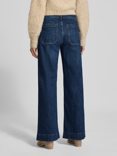 Vrouwenmodel draagt Wide Fit Jeans met opgestikte zakken model 'Gwendolin' van Christian Berg Woman in katoenmix, wide fit, achterzakken, knoop- en ritssluiting, bandwijdte maat 36: 39 cm, binnenbeenlengte maat 36: 78 cm, donkerblauw, stevige structuur. Ganzkörperansicht Rückansicht.
