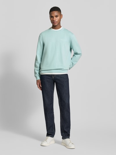 Männermodel trägt Regular Fit Sweatjacke aus reiner Baumwolle von Marc O'Polo in Hellblau, unifarben, gerippte Abschlüsse, Ganzkörperansicht von vorne.