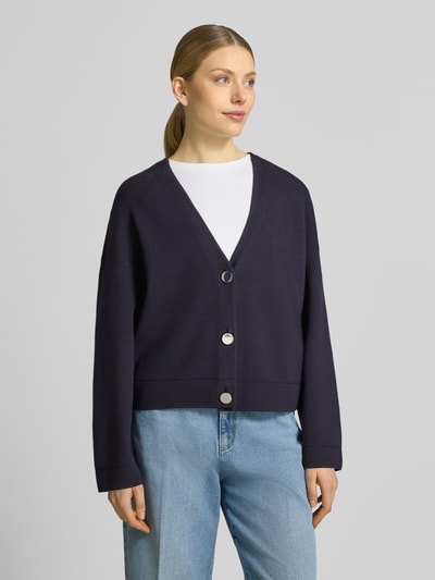 Frauenmodel trägt Strickjacke aus Viskose-Mix mit V-Ausschnitt von Comma, Relaxed-Fit, Knopfleiste, Farbe Dunkelblau, Ganzkörperansicht von vorne.